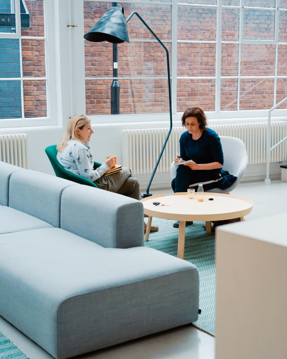 Two women sitting reviewing mining finances in a modern office space