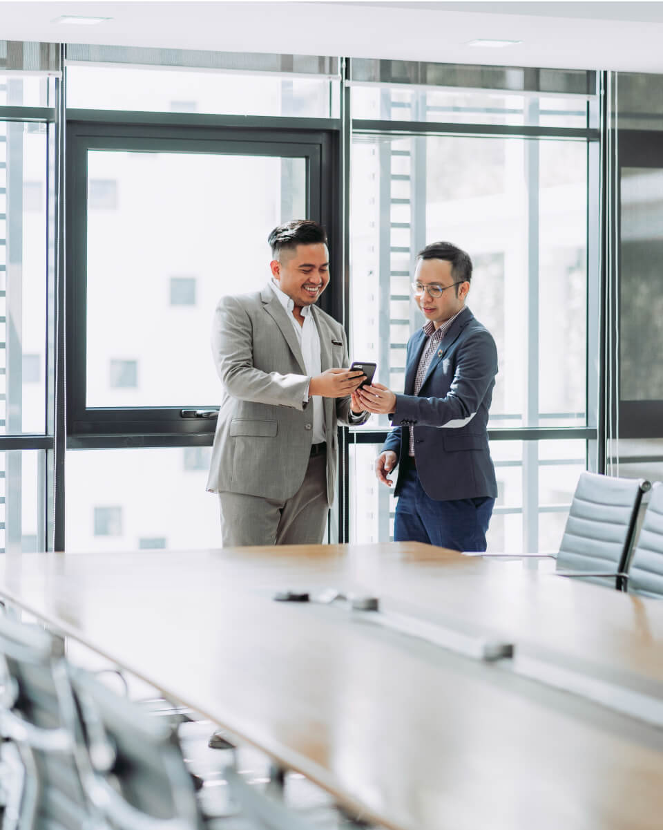 Professional team members looking on mobile device in a boardroom